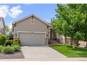 Charming home boasts a landscaped front yard, mature trees, and an attached two car garage at 1051 Bramblewood Dr, Castle Pines, CO 80108