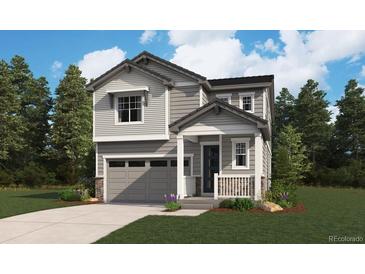 Charming two-story home featuring a gray exterior, front porch, attached garage, and landscaped yard at 11181 Mount Emma Dr, Englewood, CO 80112