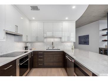 Modern kitchen featuring sleek white and wood cabinets, marble countertops, and stainless steel appliances at 1700 Bassett St # 1014, Denver, CO 80202
