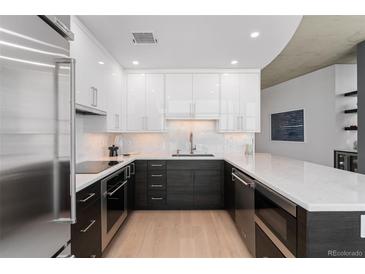 Modern kitchen featuring two-tone cabinets, stainless steel appliances, and hardwood floors at 1700 Bassett St # 1014, Denver, CO 80202