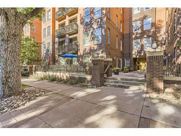 Brick condo building with updated entrance and well-maintained landscaping at 1630 N Clarkson St # 204, Denver, CO 80218