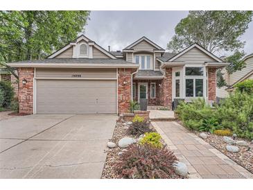 Charming two-story home with brick accents, a two-car garage, and beautiful landscaping at 19098 E Ida Dr, Aurora, CO 80015