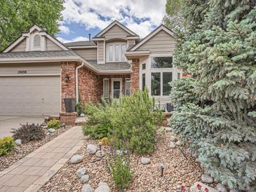 Charming two-story home with brick accents and a beautifully landscaped front yard with stone walkway at 19098 E Ida Dr, Aurora, CO 80015