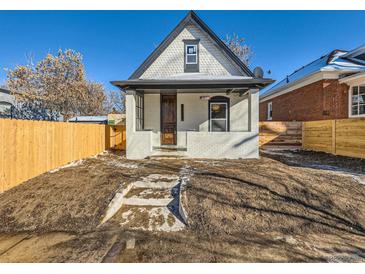 Renovated craftsman home with a white brick facade, new wood fence and landscaping at 3120 N Race St, Denver, CO 80205