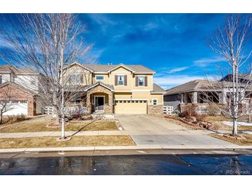 Charming two-story home featuring a stone facade, well-manicured lawn, and a spacious driveway at 24191 E Iowa Pl, Aurora, CO 80018