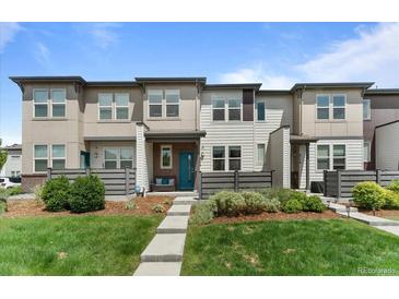 Inviting townhome with a manicured lawn and charming front porch, creating curb appeal at 4774 Kittredge St, Denver, CO 80239
