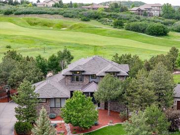 Beautiful home featuring a well-maintained lawn, mature trees, and stunning golf course views at 4586 Carefree Trl, Parker, CO 80134