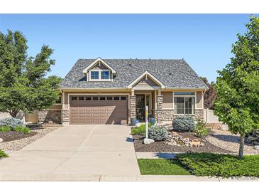 Charming home featuring a well-manicured lawn, stone accents, and a two-car garage with a large driveway at 19753 E 54Th Ave, Denver, CO 80249