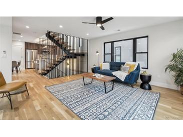 Bright living room with hardwood floors, modern staircase, and stylish decor at 2162 S Ash St, Denver, CO 80222