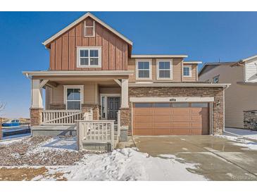 Charming two-story home featuring a welcoming front porch and an attached two-car garage at 738 N Clubview St, Watkins, CO 80137