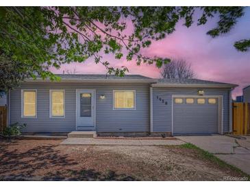 Charming one-story home featuring a garage, light gray siding and a well-manicured lawn at 1958 Cathay Ct, Aurora, CO 80011