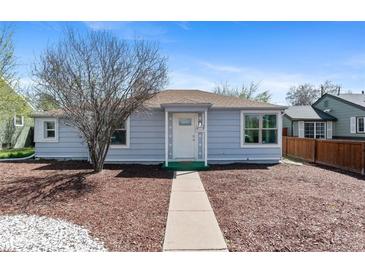 Charming home featuring light blue siding and a well-manicured front yard with mature trees at 1740 Trenton St, Denver, CO 80220