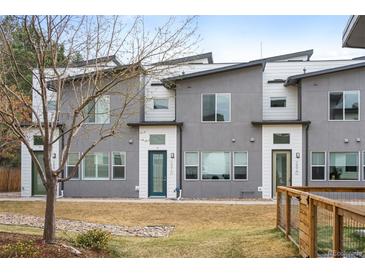 Contemporary townhome exterior showcases gray stucco, white trim, and a well-kept lawn at 5810 W 39Th Pl, Wheat Ridge, CO 80212