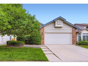 Charming home with a two-car garage, fresh lawn, mature tree, and lovely front yard landscaping at 2247 S Lima Ct, Aurora, CO 80014