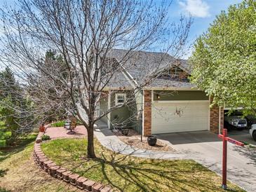 Charming home with stone accents, a two-car garage, manicured lawn, and walkway to the front door at 6701 W Yale Ave, Lakewood, CO 80227