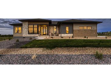 Stunning home exterior with manicured lawn, stone accents, and modern design elements at 8868 Geyser Peak Way, Parker, CO 80138