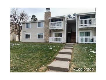 Traditional-style condo building with an exterior balcony and landscaped yard at 14493 E Jewell Ave # 102, Aurora, CO 80012