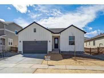 Charming single-Gathering home with gray garage door, contrasting trim, and minimal landscaping at 1306 Sienna Peak Cir, Erie, CO 80516