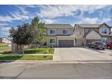 Charming two-story home boasts a well-maintained lawn, a spacious driveway, and an attached two-car garage at 4996 Cathay Ct, Denver, CO 80249