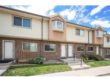 Charming multi-Gathering home with brick and vinyl siding, front lawn and steps leading to front door at 6920 W 48Th Ave, Wheat Ridge, CO 80033