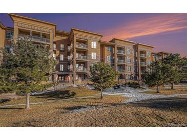 Attractive multi-unit building with landscaping and a sunset backdrop at 7865 Vallagio Ln # 308, Englewood, CO 80112