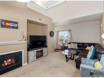 Comfortable living room featuring a fireplace, TV, and a large sectional couch for ample seating at 5800 Tower Rd # 610, Denver, CO 80249
