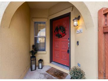 Inviting front entrance with red door, wreath, and lantern lights at 9624 Martin Luther King Blvd, Denver, CO 80238