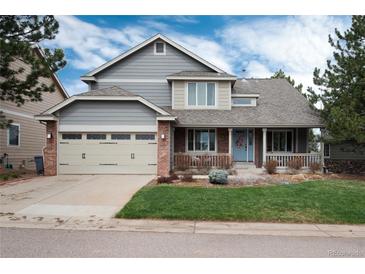 Charming two-story home with a well-maintained front yard and a two car attached garage at 49 Dawn Heath Cir, Littleton, CO 80127