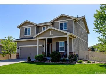 Charming two-story home with manicured lawn, covered porch, and attached garage at 11158 Carbondale St, Firestone, CO 80504