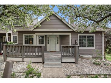 Charming home featuring a classic facade, inviting front porch, and flowering trees in a pleasant surrounding landscape at 6780 W 84Th Cir # 66, Arvada, CO 80003