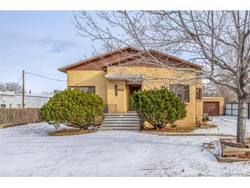 Brick ranch home with a spacious yard and attached garage at 3780 Benton St, Wheat Ridge, CO 80212