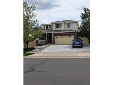 Charming two-story home featuring a brick facade, two-car garage, and inviting front porch at 20928 E Hamilton Ave, Aurora, CO 80013