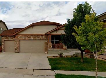 Charming single-Gathering home with a two-car garage, stone accents, and a cozy front porch at 5131 Delphinium Cir, Brighton, CO 80601