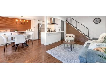Open-concept living and dining area with wood floors, statement wall, and modern decor at 3355 S Flower St # 95, Lakewood, CO 80227