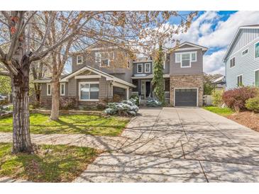 Charming two-story home with a stone facade and a spacious driveway, complemented by green landscaping at 14223 Piney River Rd, Broomfield, CO 80023