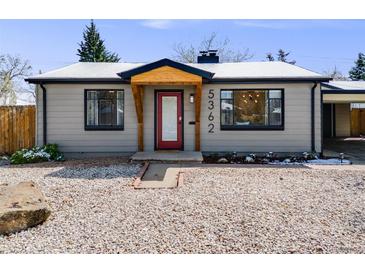 Charming one-story home with a minimalist rock yard, red door, and natural wood entry covering at 5362 S Cedar St, Littleton, CO 80120