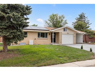 Charming, ranch-style brick home with a well-maintained lawn, solar panels, and attached garage at 5329 Flower Cir, Arvada, CO 80002