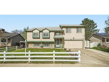 Two-story home featuring well-maintained landscaping and a white picket fence at 5987 S Pierson St, Littleton, CO 80127