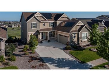 Beautiful home exterior with solar panels, manicured lawn and long driveway at 8761 S Wenatchee Ct, Aurora, CO 80016