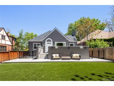 Charming gray home featuring an outdoor living space with seating and an expansive artificial lawn at 420 N Colorado Blvd, Denver, CO 80206