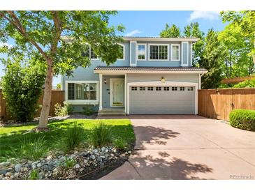 Charming two-story home with a two-car garage, manicured lawn and mature trees at 1526 Braewood Ave, Littleton, CO 80129