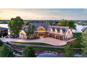 Stunning waterfront home features a large circular driveway, mature landscaping, and a four-car garage at 9833 Shoreline Dr, Longmont, CO 80504