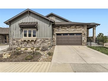 Charming home exterior with stone accents, a two-car garage, and a well-maintained front yard at 3477 New Haven Cir, Castle Rock, CO 80109