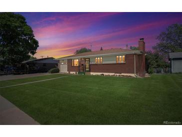 Charming brick home with a well-maintained lawn, mature trees, and inviting curb appeal at 392 Central Ave, Brighton, CO 80601