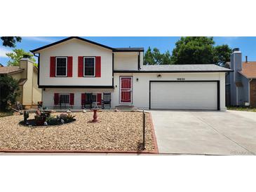 Charming two-story home featuring red shutters, a well-kept lawn, and an attached two-car garage at 19630 E Purdue Pl, Aurora, CO 80013