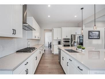 Modern kitchen featuring white cabinets, stainless steel appliances, and sleek countertops at 6733 S Waterloo Ct, Aurora, CO 80016