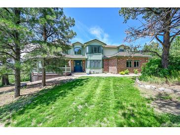 Beautiful two-story home with manicured lawn and mature trees providing curb appeal at 6681 Flintwood Rd, Parker, CO 80138