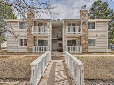 Inviting exterior of multi-Gathering home with stone accents and charming white bridge walkway at 14131 E Jewell Ave # 104, Aurora, CO 80012