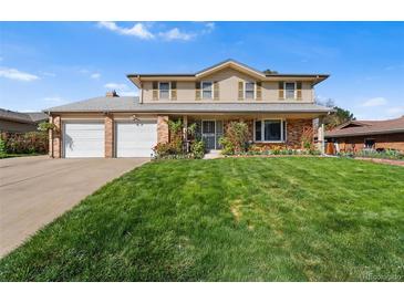 Charming two-story home featuring a well-manicured lawn, brick accents, and a two-car garage at 3191 S Holly Pl, Denver, CO 80222