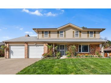 Charming two-story home with a well-manicured lawn, two-car garage, and light beige siding at 3191 S Holly Pl, Denver, CO 80222